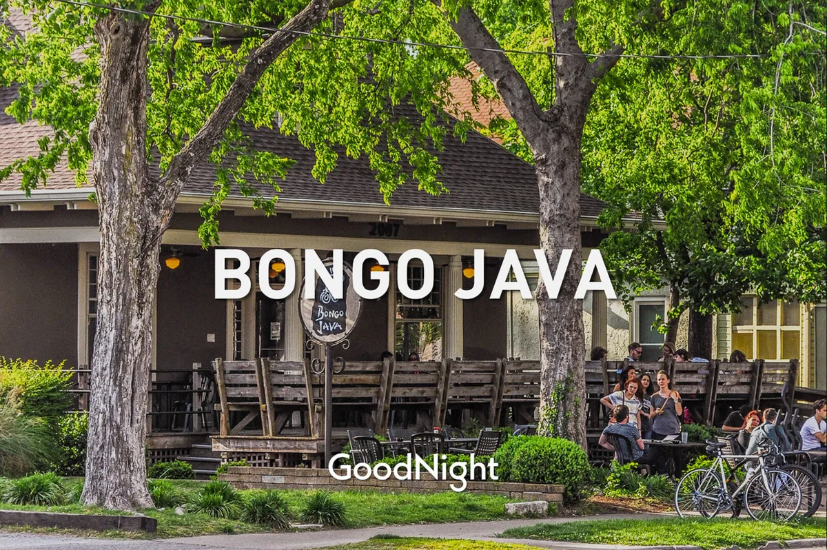 This inviting exterior shows the Bongo Java coffeehouse sign, outdoor seating, and people socializing on a lively street. The casual atmosphere and neighborhood vibe are complemented by greenery and the presence of bicyclists, hinting at a walkable, friendly community.